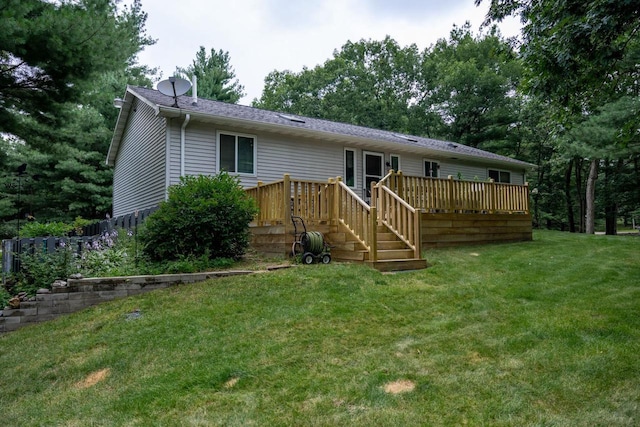 back of property featuring a deck and a lawn