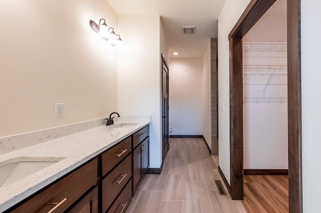 bathroom with hardwood / wood-style flooring, vanity, and toilet