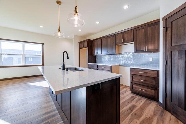 kitchen with ceiling fan, sink, dark hardwood / wood-style floors, and a kitchen island with sink