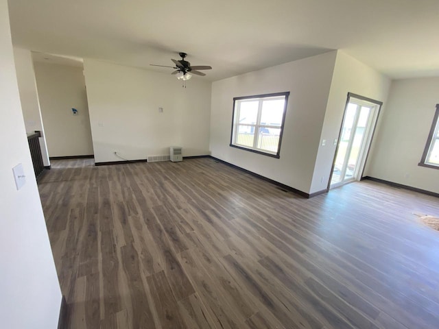 unfurnished living room featuring dark hardwood / wood-style floors and ceiling fan