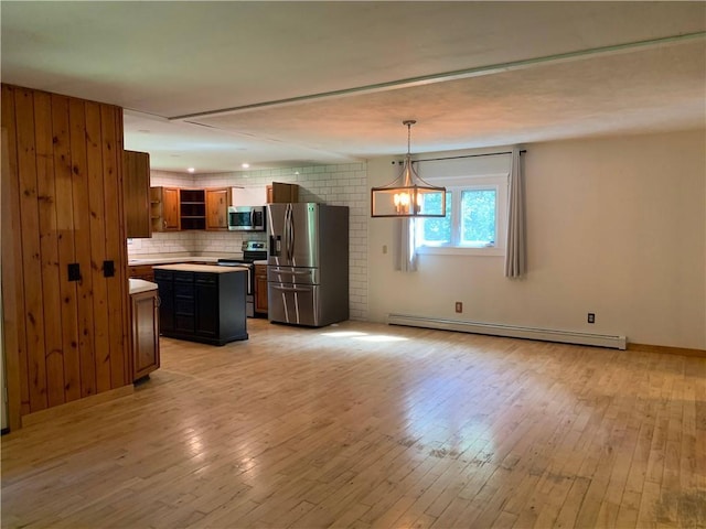 kitchen with appliances with stainless steel finishes, a kitchen island, decorative light fixtures, a baseboard heating unit, and light hardwood / wood-style floors