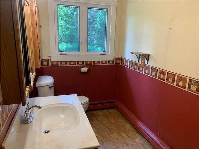 bathroom with a baseboard heating unit, toilet, and vanity