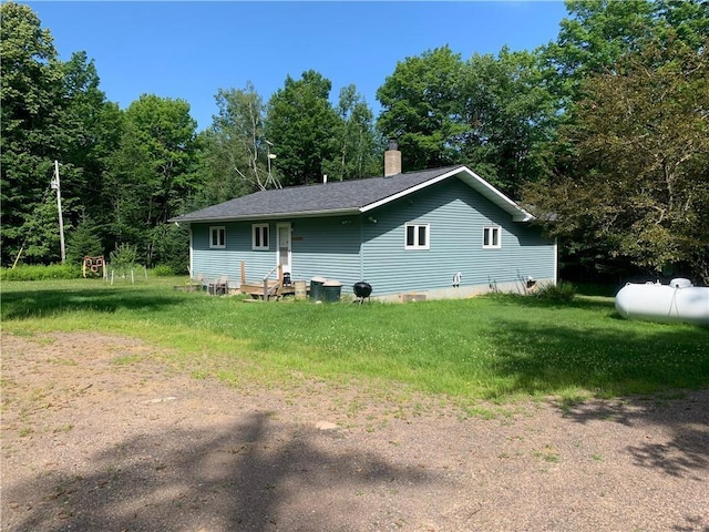 rear view of property featuring a yard