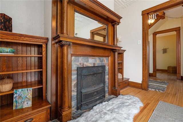 living room featuring a tiled fireplace and light hardwood / wood-style floors