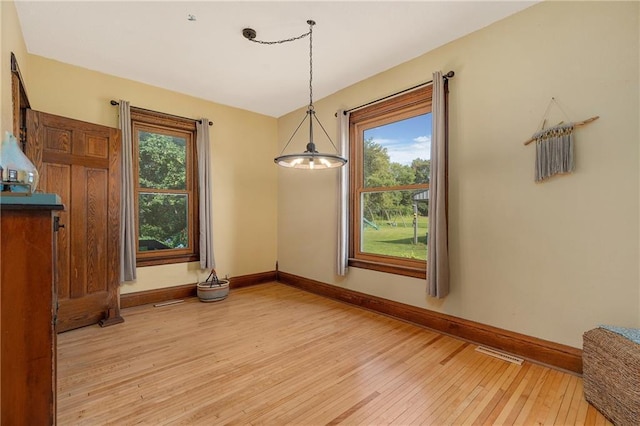 unfurnished dining area with a wealth of natural light and light wood-type flooring