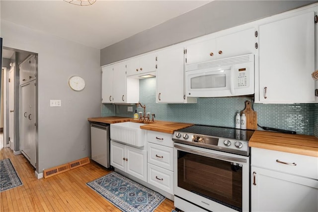 kitchen with white cabinetry, appliances with stainless steel finishes, sink, and backsplash