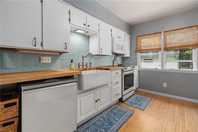 kitchen with white cabinetry, dishwasher, sink, and electric range