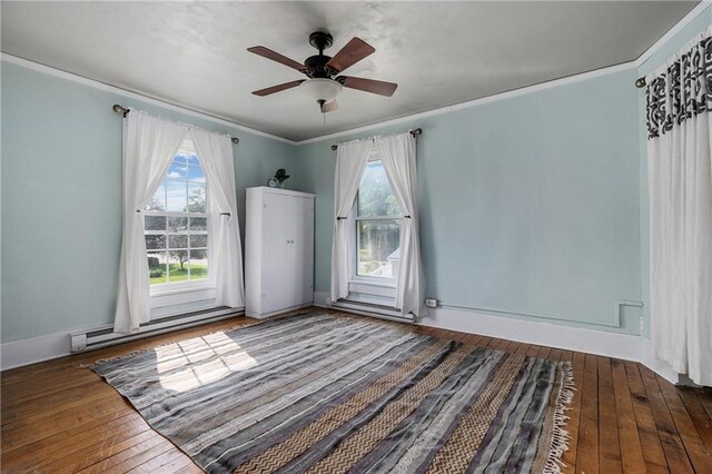 unfurnished room featuring ornamental molding, dark hardwood / wood-style floors, ceiling fan, and baseboard heating