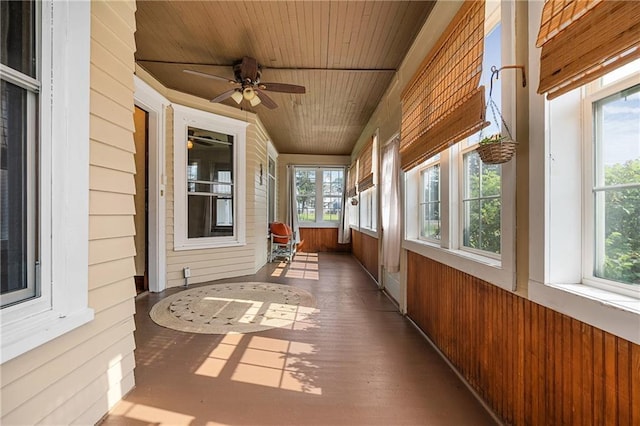 unfurnished sunroom featuring wood ceiling and ceiling fan