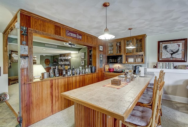 bar featuring decorative light fixtures and carpet floors