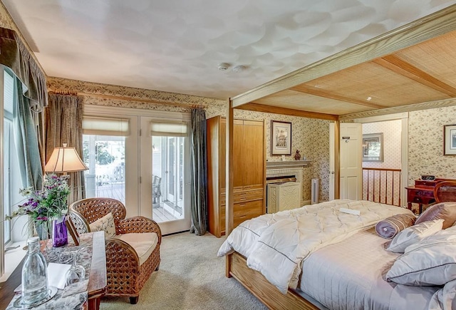 carpeted bedroom featuring beam ceiling and access to outside