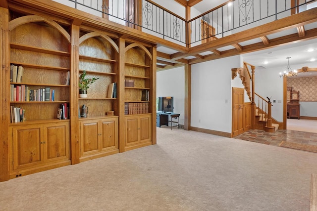 carpeted living room with built in shelves and an inviting chandelier