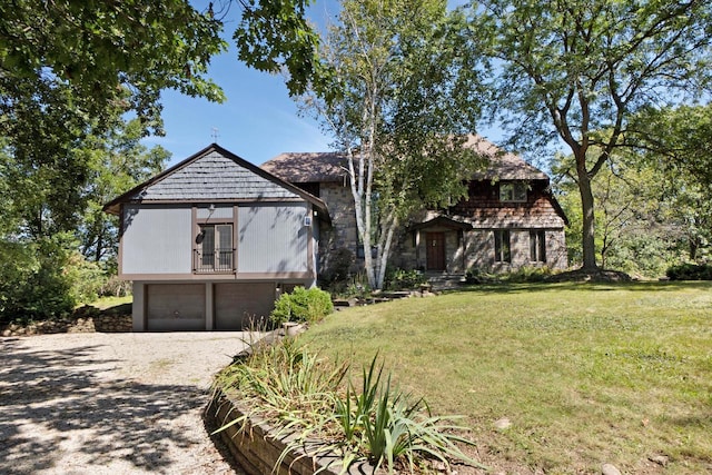 english style home featuring a garage and a front lawn