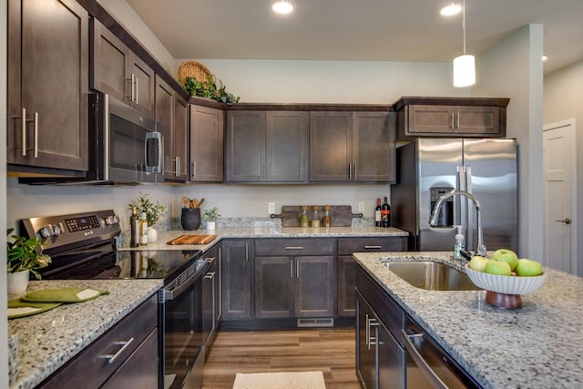 kitchen with light hardwood / wood-style floors, sink, dark brown cabinetry, light stone countertops, and stainless steel appliances