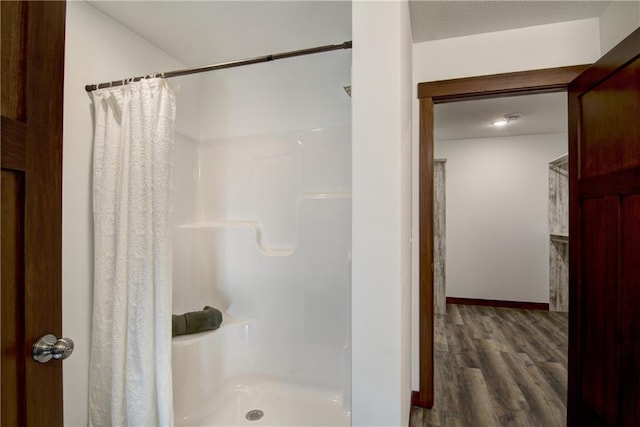 bathroom featuring hardwood / wood-style flooring and walk in shower