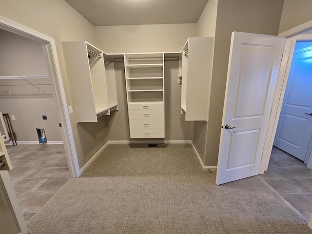 walk in closet featuring light colored carpet