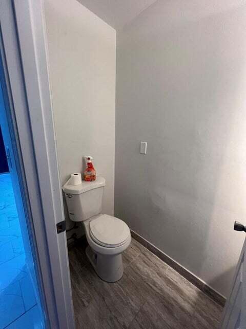 bathroom with hardwood / wood-style flooring and toilet