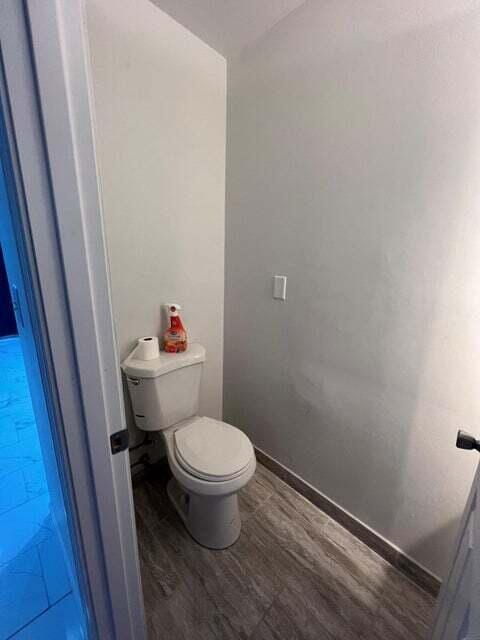 bathroom with toilet and hardwood / wood-style floors