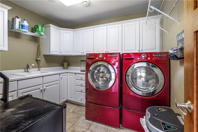 laundry room featuring light tile patterned flooring, cabinets, washer and clothes dryer, and sink