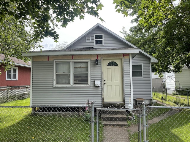 bungalow-style home with a front yard