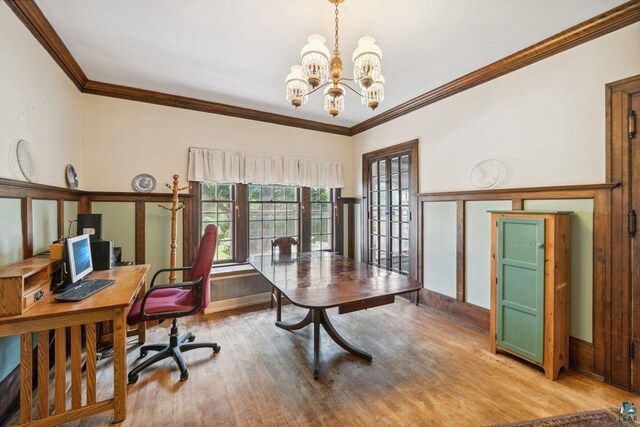 home office featuring ornamental molding, a notable chandelier, and light hardwood / wood-style flooring