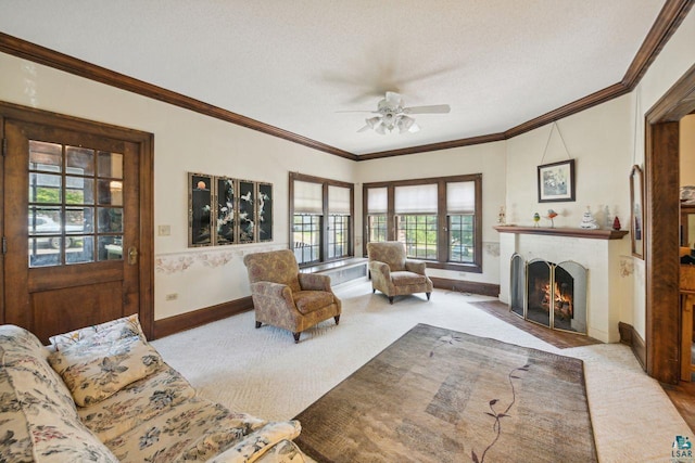 carpeted living room featuring crown molding, ceiling fan, and a textured ceiling