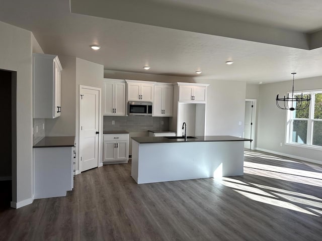 kitchen featuring white cabinetry, sink, a kitchen island with sink, and dark hardwood / wood-style flooring