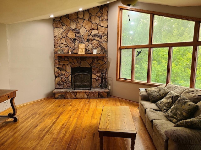 living area featuring lofted ceiling, a fireplace, and wood finished floors