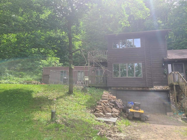 view of front facade featuring a deck, driveway, and an attached garage