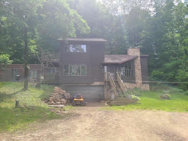 view of front of home featuring dirt driveway, a chimney, and an attached garage