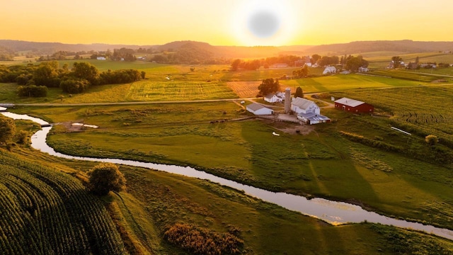 aerial view at dusk with a water view and a rural view