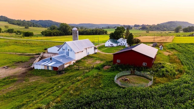 aerial view at dusk featuring a mountain view and a rural view