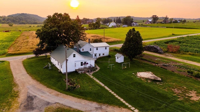 aerial view at dusk with a mountain view and a rural view