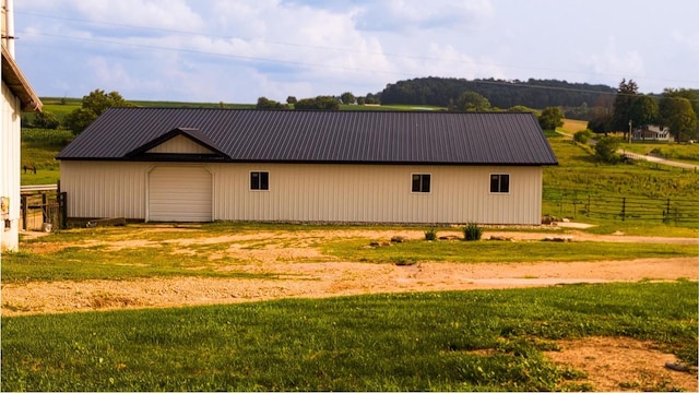 view of side of home with a garage, a lawn, and an outdoor structure