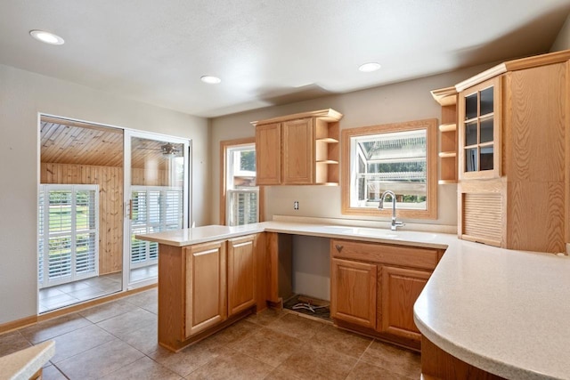 kitchen featuring sink, light tile patterned floors, and kitchen peninsula