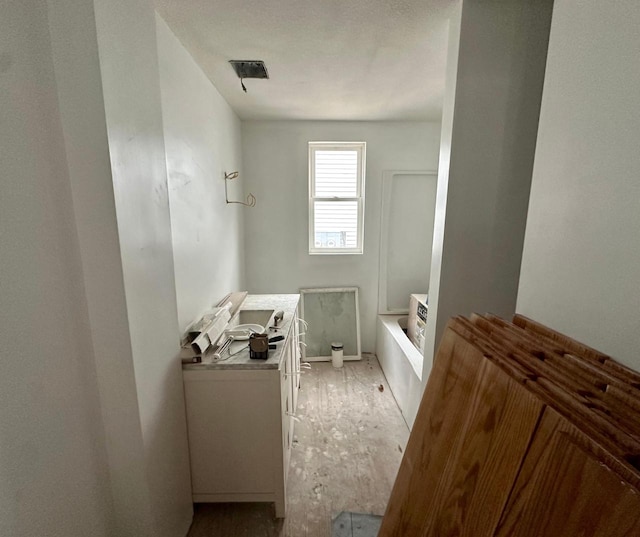 bathroom featuring a tub to relax in and vanity