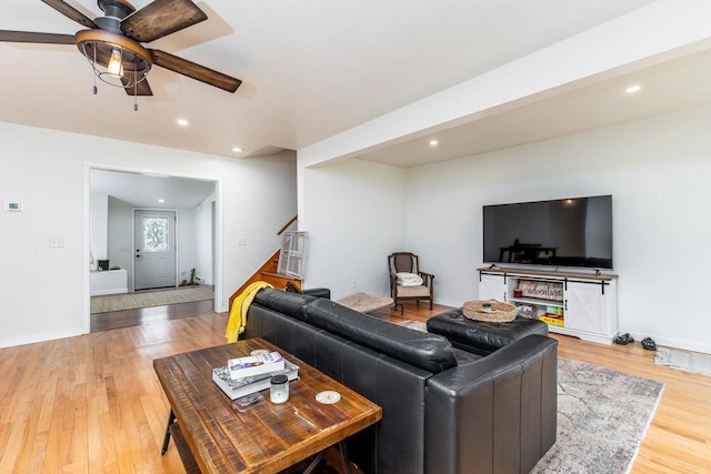 living room with light wood-type flooring and ceiling fan