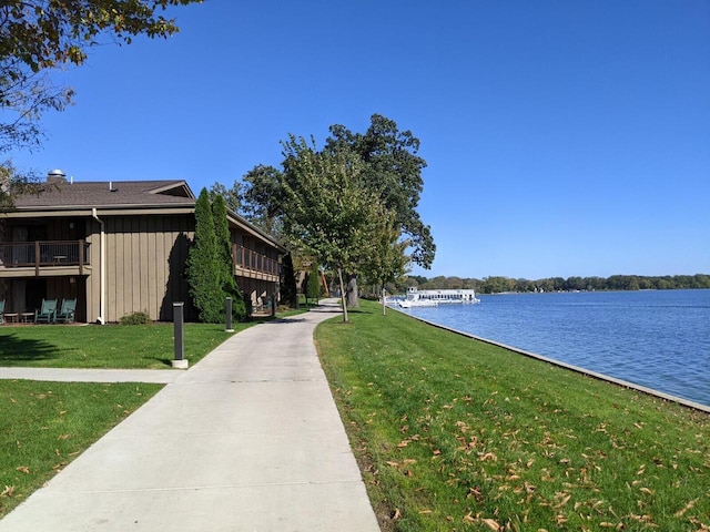 view of community with a lawn and a water view