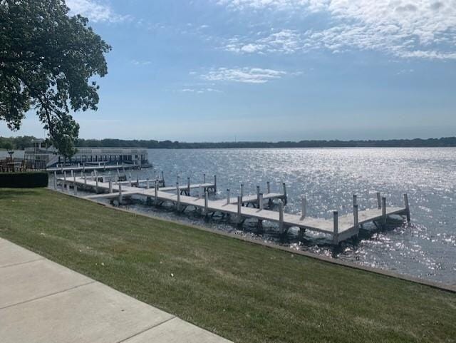 dock area with a water view and a lawn