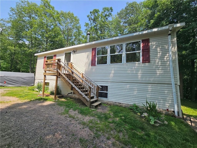 view of front of house with a wooden deck and a front yard