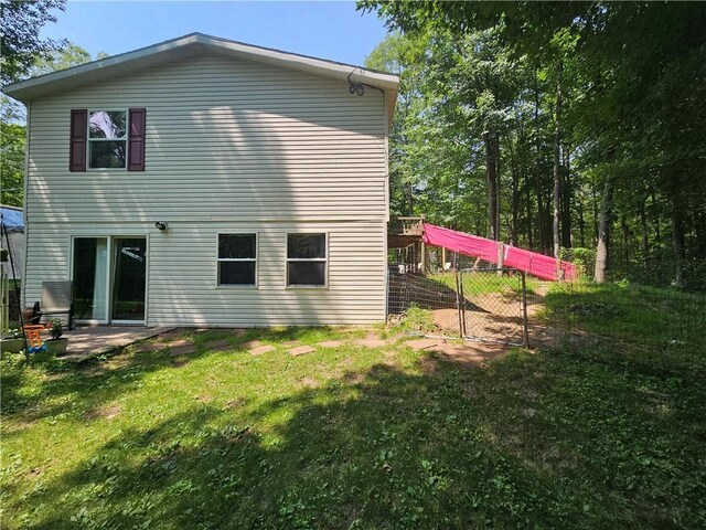 rear view of house featuring a yard