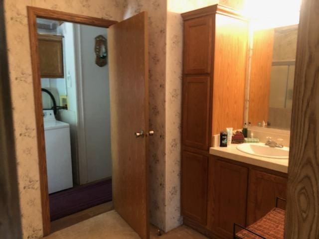 bathroom featuring vanity and washer / dryer