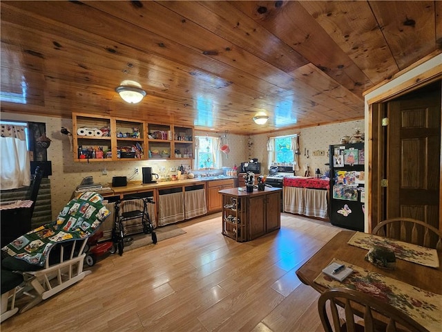 kitchen with black refrigerator, wood ceiling, and light hardwood / wood-style flooring