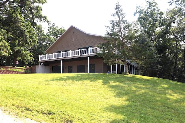 rear view of house featuring a lawn and a deck