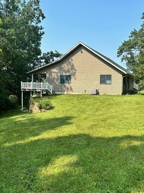 view of home's exterior with a deck and a lawn