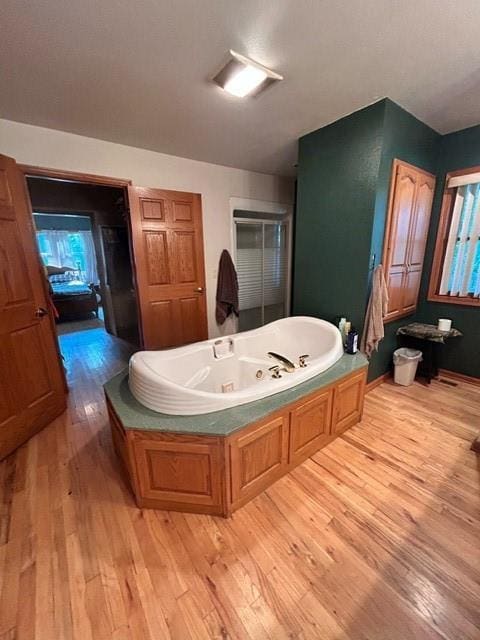 bathroom with a bath and hardwood / wood-style flooring