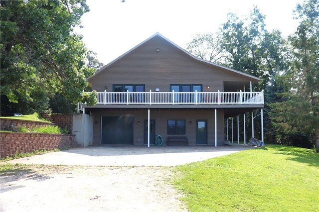 back of house with a wooden deck, a garage, and a yard