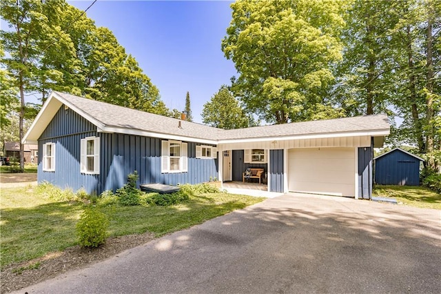 23855 Garden Lake Rd, Cable, WI 54821 - ranch-style home featuring board and batten siding, a garage, driveway, a front yard, and roof with shingles