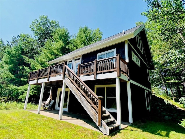 back of property featuring a wooden deck, a yard, and a patio area