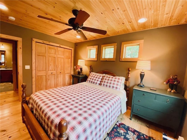 bedroom featuring ceiling fan, a closet, light hardwood / wood-style flooring, and wooden ceiling